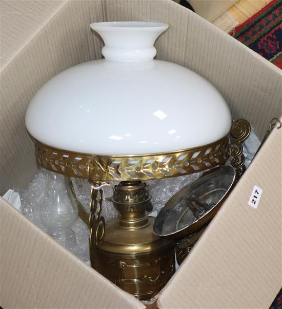 A brass hanging oil lamp with white glass shade